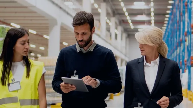 Directivos con operario revisando el reaprovisionamiento dinámico del stock.