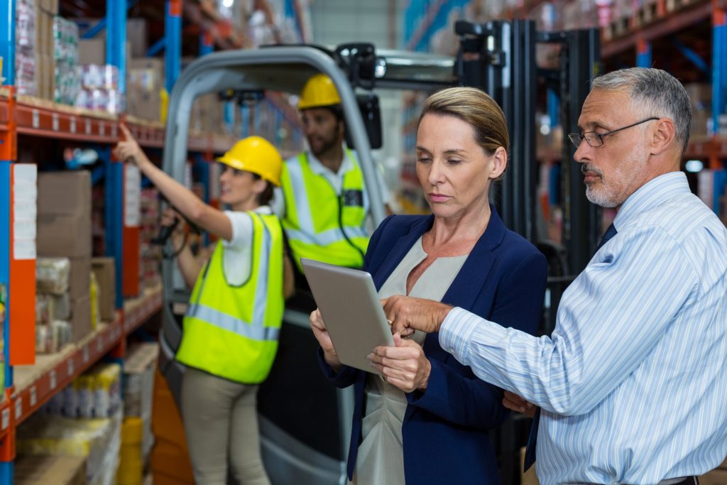 Serious managers are looking a tablet in warehouse