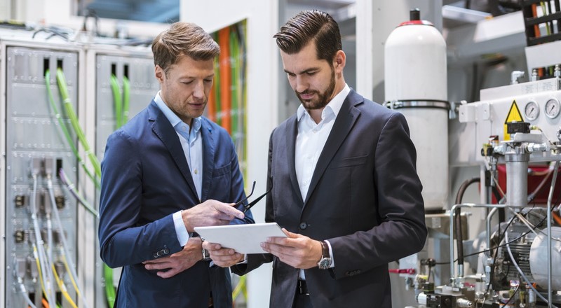 Dos directivos en la fábrica revisando el Plan Maestro de Producción (MPS).