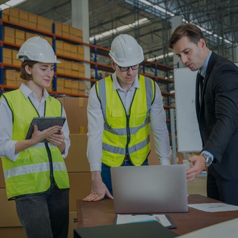 Directivos revisando la Optimización de Inventario Multinivel (MEIO) con un trabajador.